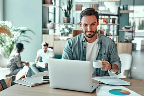 Smiling businessman using laptop computer in cafe Stock Photos