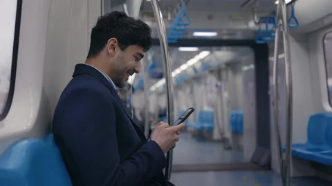 Smiling businessman using mobile in subway car Stock Footage 154394651