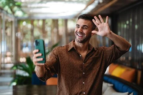 Smiling businessman using smartphone for communication in a modern cafe int.. Stock Photos