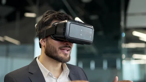 Smiling businessman using VR glasses for video call and online chat in virtual  Video stock 319777668