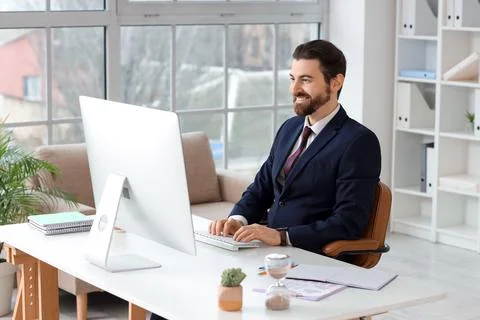 Smiling businessman working on computer in modern office, professional produc 스톡 사진