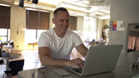 Smiling businessman working on laptop computer at home office. Male professional Stock-Footage 209490211