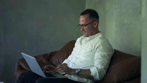 Smiling businessman working on laptop computer at home office. Male professional Stock Footage 209948782