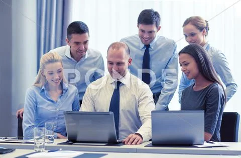 Smiling businesspeople with laptops in office Stock Photos