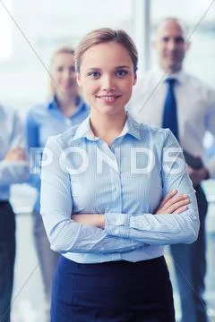 Smiling businesswoman with colleagues in office Stock Photos