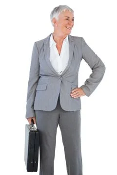 Smiling businesswoman holding briefcase and putting her hand on hip Stock Photos