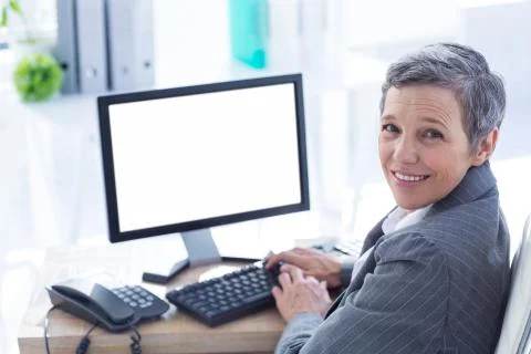 Smiling businesswoman using computer Stock Photos