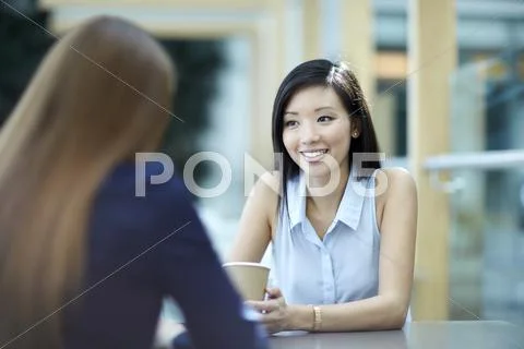 Smiling businesswomen talking on coffee break Stock Photos
