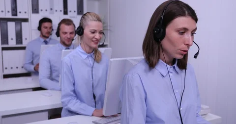 Smiling Call Center Agents Working with Headsets in a Financial Company Office Stock Footage 85539492