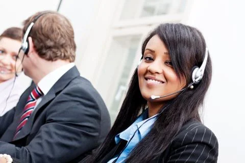Smiling callcenter agent with headset support Stock Photos