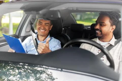 Smiling car driving school instructor and driver Stock Photos