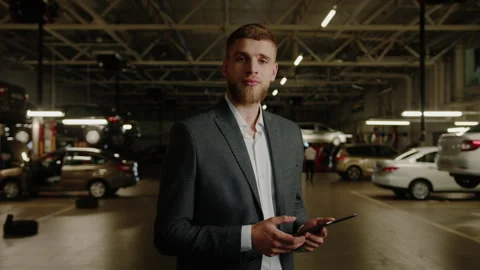 Smiling car quality control manager after repair with a tablet in his hands Stock Footage 256073970