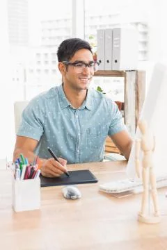 Smiling casual businessman using computer and digitizer Stock Photos