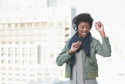 Smiling casual model dancing while listening to music Stock Photos