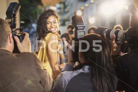 Smiling celebrity turning towards photographing paparazzi photographers Stock Photos