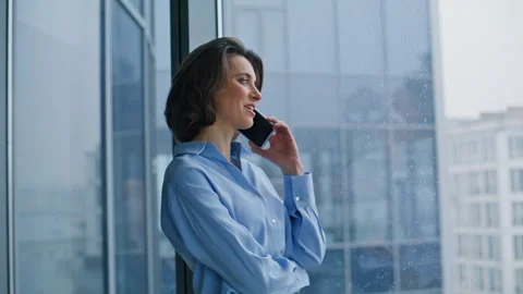 Smiling ceo talking mobile phone standing panoramic window closeup. Happy woman Stock Footage 345924317
