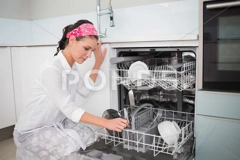 Smiling charming woman using dish washer Stock Photos