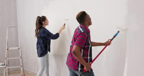 Smiling cheerful friends having fun while renovating finishing an apartment Stock Footage 169459130