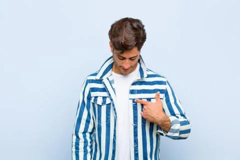 Smiling cheerfully and casually, looking downwards and pointing to chest Stock Photos
