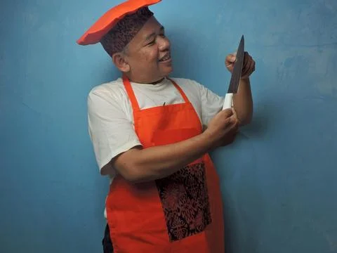 Smiling Chef Admiring Kitchen Knife in Studio Setting Stock Photos