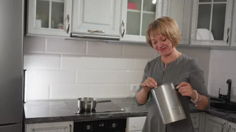 Smiling Chef Dances and Stirs Liquid Sugar Mixture in Cozy Modern Kitchen Stock Footage 307990859