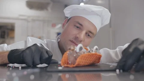 Smiling chef decorating ice-cream dessert with sprinkles Stock Footage 125051489