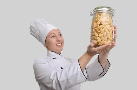 Smiling chef holding jar of ditalini pasta: culinary expertise and italian .. Stock Photos