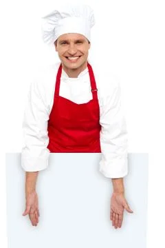 A smiling chef posing behind white billboard Stock Photos