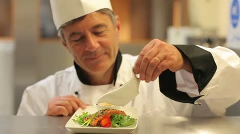 Smiling chef pouring dressing over salmon dish Stock Footage 12765028