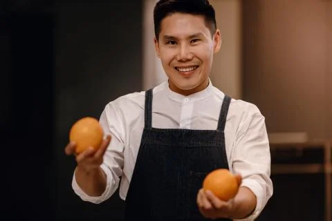 A Smiling Chef with some Oranges in Hands, Preparing for Vegan Food or Delici Stock Photos