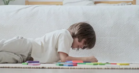 Smiling child boy focused constructing architecture with colorful wooden brick Stock Footage 162479735