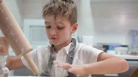 Smiling child covered in flour baking gingerbread cookies 스톡 동영상 324558567