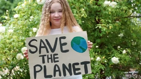 Smiling child looking to camera with save planet ecology poster in hands. sch Stock Footage 134906435