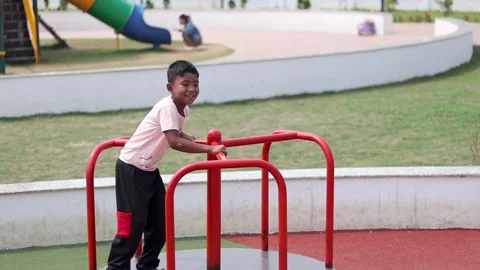 Smiling Child Playing on Merry-Go-Round at Public Playground in Dibrugarh Stock Footage 334774338