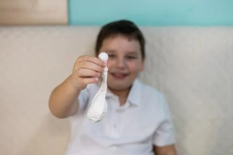 A smiling child practices autoinsufflation using a nasal balloon to equalize Stock Photos