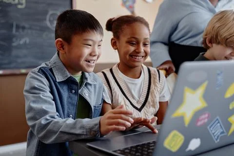 Smiling Children Studying with Help of Computer Stock Photos