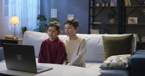 Smiling children using laptop talking by webcam with friends or relatives in Stock Footage 267744498