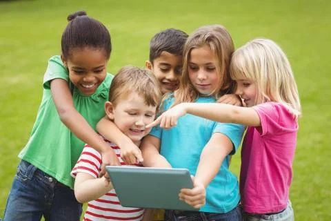 Smiling classmates using tablet together Stockfoto's
