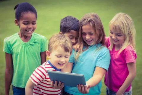 Smiling classmates using tablet together 스톡 사진