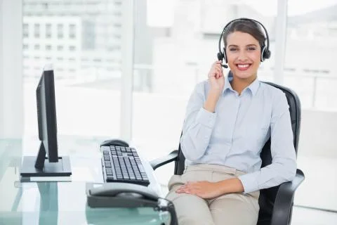 Smiling classy brown haired operator answering a call Stock Photos