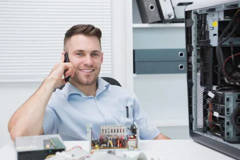 Smiling computer engineer on call by open cpu Foto stock