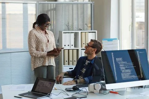 Smiling Computer Programmer Talking to Assistant Stock Photos