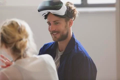 Smiling computer programmer wearing virtual reality simulator glasses 写真素材