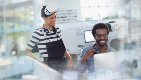 Smiling computer programmers programming virtual reality simulator in office Stock Photos