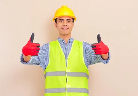 Smiling confident asian construction worker wearing safety vest and hard ha.. Stock Photos