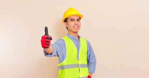 Smiling confident asian construction worker wearing safety vest and hard ha.. Stock Photos