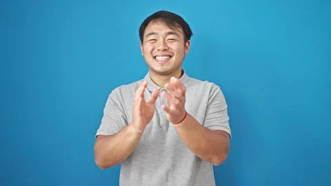 Smiling confident clapping applause over isolated blue background Stock Footage 248876827