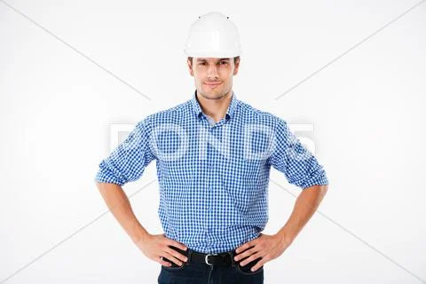 Smiling confident young man builder in building helmet Stock Photos