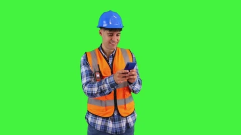 Smiling construction engineer sending messages and emails with his smartpho.. Stock Footage 286986144