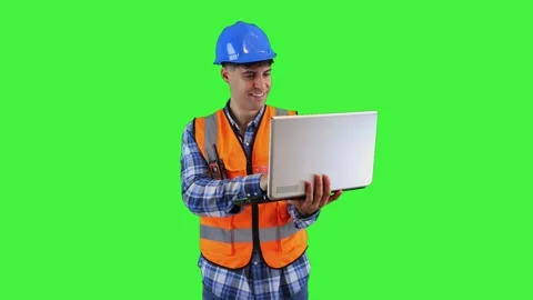 Smiling construction engineer typing on laptop, wearing orange vest and saf.. Stock Footage 286985782